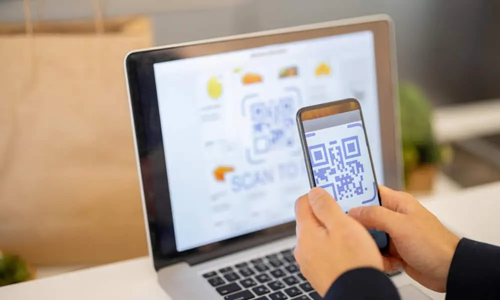 User scanning QR code on PC screen to link phone with Windows